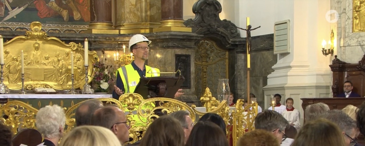 Generalsekretär Matthias Ristau am Rednerpult im Michel. Er trägt den weißen Helm mit Logo der Seemannsmission und eine gelbe Leuchtweste. Vorne sind die Köpfe der Politiker von schräg hinten zu sehen
