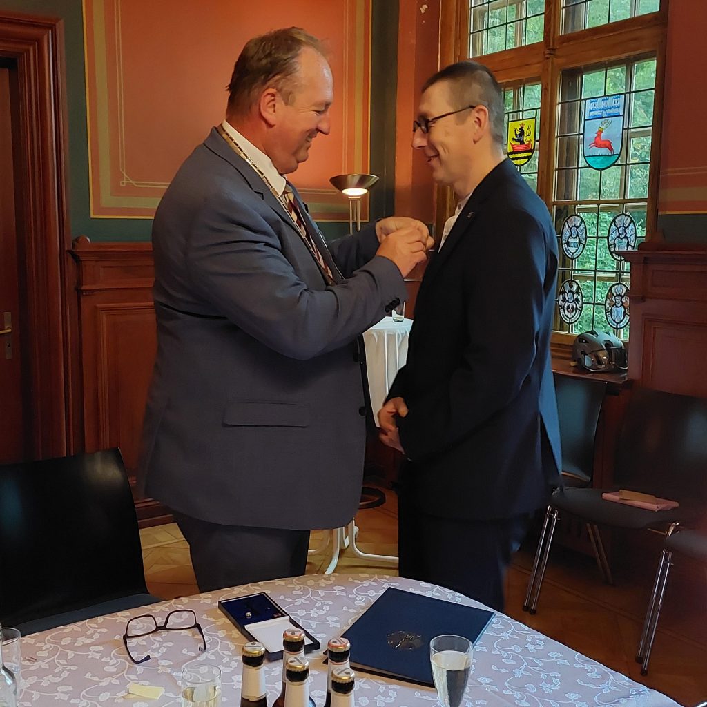 Der Cuxhavener Oberürgermeister Uwe Santjer heftet Martin Struwe das Bundesverdienstkreuz an  