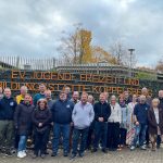 Konferenz IMAK 2023 auf dem Koppelsberg. Gruppenbild vor der Mauer mit dem Namen der Bildungsstätte