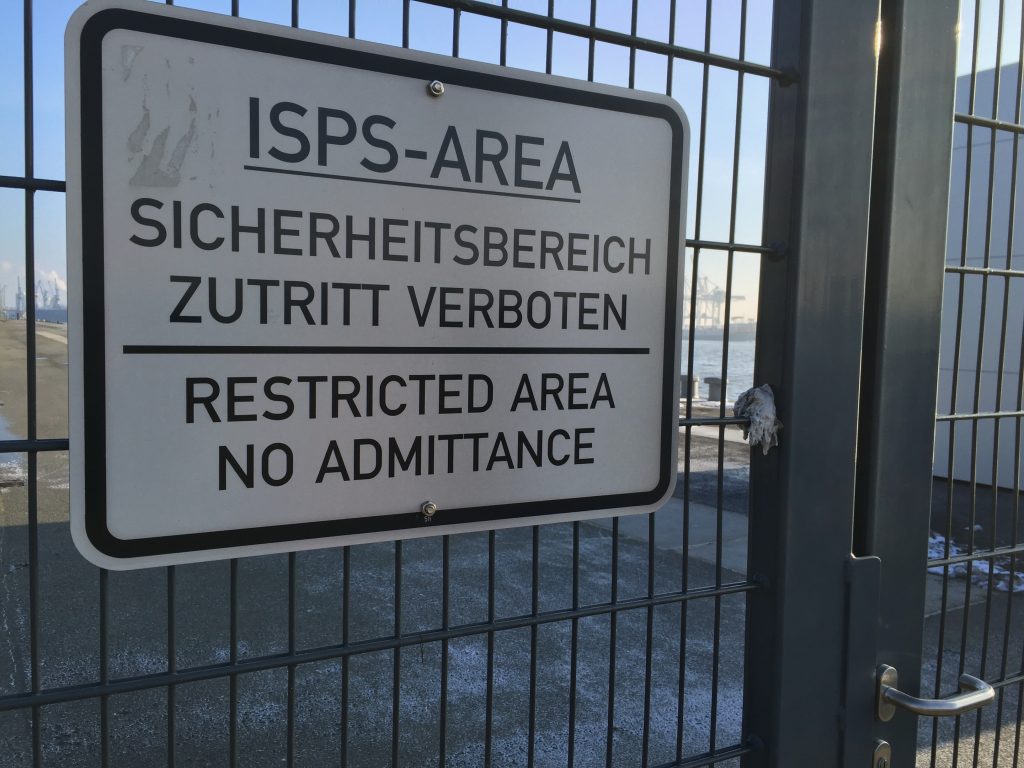 An einer Gittertür hängt ein Schild: ISPS Area Sicherheitsbereich - Zutritt verbotem Restricted Area, no admittance
