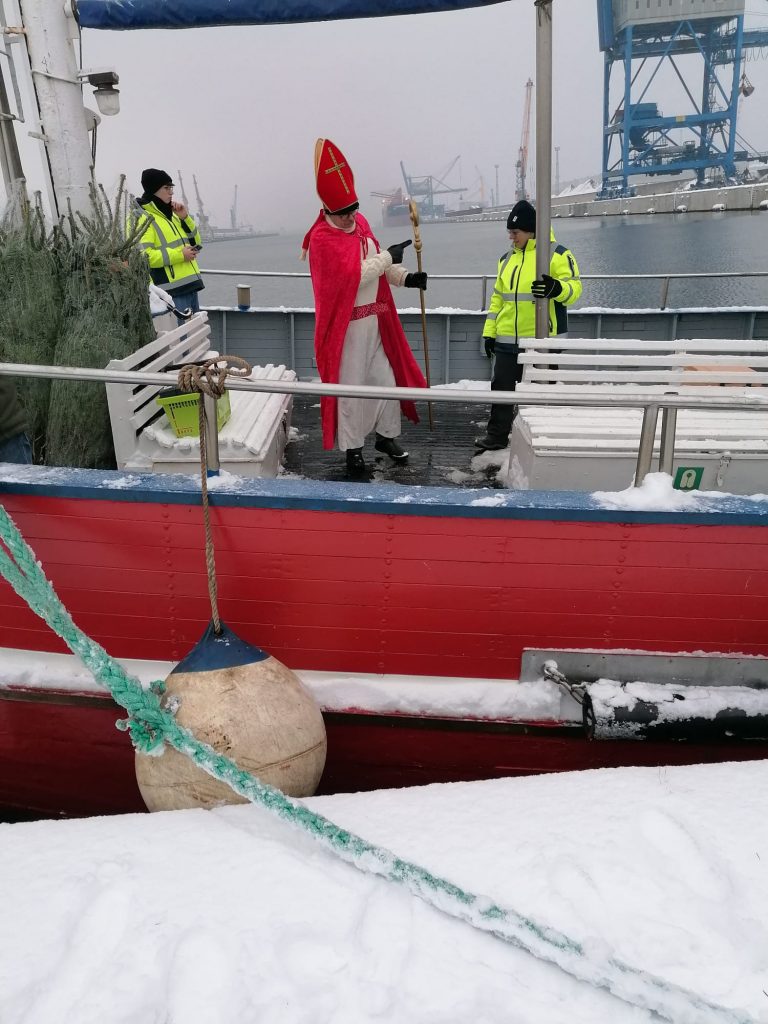 Rostock: der Nikolaus auf einem kleinen Schiff mit Tannenbäumen für die Seeleute