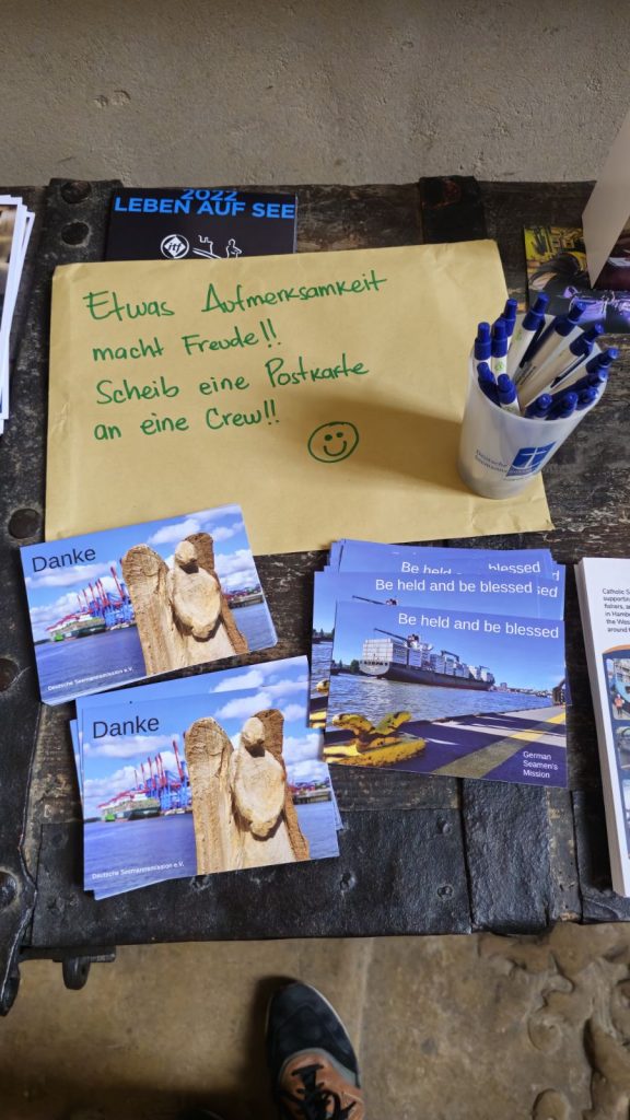 Postkarten liegen auf dem  Tisch. Besucher können dort Grüße an Seeleute schriebn. 