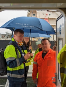 Zwei Freiwillige bei einem Schiffsbesuch im Hafen von Rotterdam.
