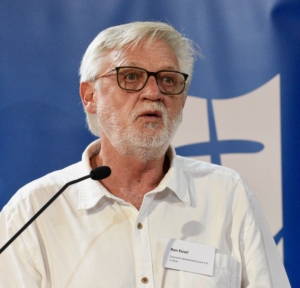 Das Foto zeigt Seemannspastor Ron Küsel, der den Standort der Deutschen Seemannsmission im südafrikanischen Durban leitet. Hier sieht man ihn als Referent am Podium beim Symposium zum Thema Tod und Sterben an Bord.