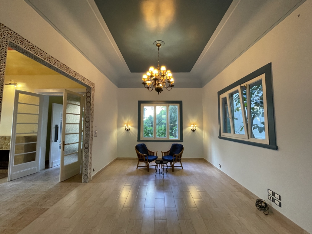 Das Foto zeigt das Wohnzimmer des Gästeshauses der Deutschen Seemannsmission im ägyptischen Alexnadria kurz nach der Renovierung. Die Böden sind aus Holz, an der Decke hängt ein Kronleuchter, die Wände sind weiß gemalt, die Fensternischen in einem dunklen Petrolton akzentuiert.