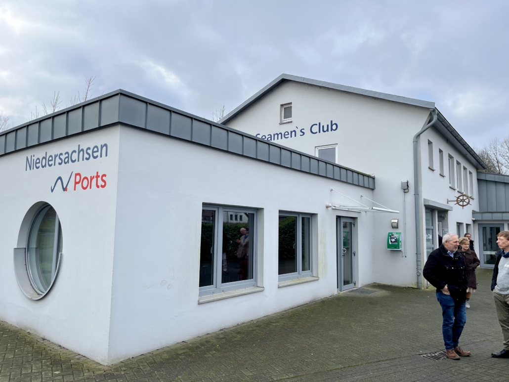 Das Foto zeigt die Aussenansicht des Seemannsclubs Pier One in Brake. Die ein- bzw. zweistöckig gebauten Gebäudeteile sind weiß-gestrichen. Die Dachkante ist hellgrau.