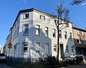 Das Foto zeigt die Hausansicht der Deutschen Seemannsmission Duisburg in der Dr. Hammacher-Straße in Duisburg. Es ist ein kalter, aber sonniger Wintertag. Die Bäume tragen keine Blätter. Der Himmel ist blau. Das Haus ist weiß-grau gestrichen. Es ist eine ruhige Wohnlage. Parallel zur Straße parken PKW.