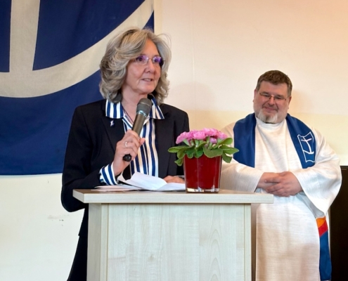 Das Foto zeigt die neue Leiterin des Seemannsclubs Duckdalben, Eliane Lafendt, und ihren Kollegen und Leiter der Bordbetreuung Hamburg, Jörn Hillfe. Lafendet trägt eine senkrecht blau-weiß gestreifte Bluse und einen schwarzen Blazer. Ihre mittellangen, grauen Haare trägt sie offen. Schrägt hinter Eliane Lafendt steht Seemannsdiakon Jörn Hille.