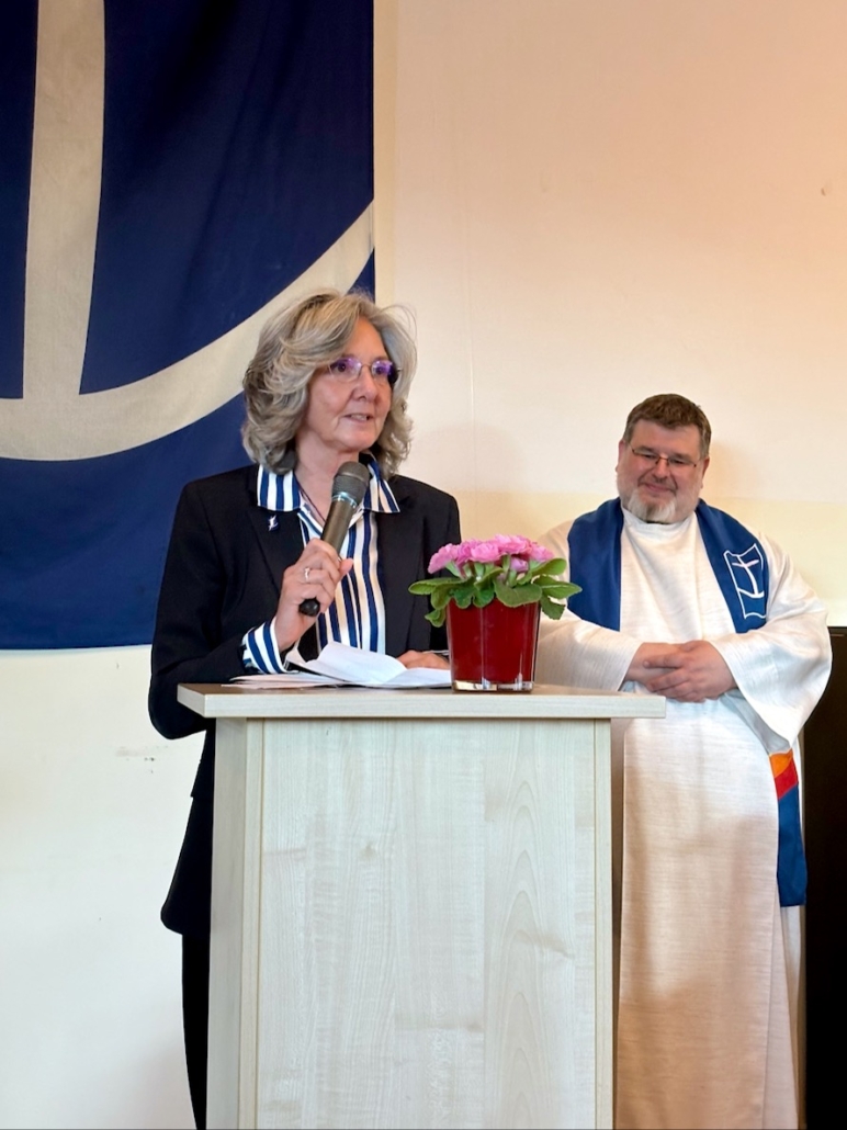 Das Foto zeigt die neue Leiterin des Seemannsclubs Duckdalben, Eliane Lafendt, und ihren Kollegen und Leiter der Bordbetreuung Hamburg, Jörn Hillfe. Lafendet trägt eine senkrecht blau-weiß gestreifte Bluse und einen schwarzen Blazer. Ihre mittellangen, grauen Haare trägt sie offen. Schrägt hinter Eliane Lafendt steht Seemannsdiakon Jörn Hille.