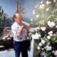 Das Foto zeigt den ehemaligen Seemannsdiakon Walter Bott auf der Terrasse des Seemannsheims in Piräus. Bott war ein begnadeter Gärtner, züchtete Rosen und ernetete jedes Jahr kiloweise Tomaten. Das Foto ist Ende der 1980er Jahre entstanden und zeitgt ihn in einem kurärmeligen weißen Hemd und langer dunkler Hose. Die Sonne scheint, im Hintergrund sind Kakteen zu sehen, die in Töpfen ebenfalls auf der Terrasse stehen.