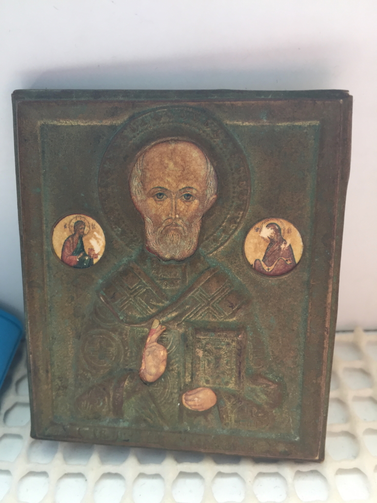 Ein einfache Ikone von St. Nikolaus aus Holz auf einer weißen Antirutschmatte in der Kammer eines Seemanns