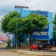 Das Foto zeigt das sogenannte Blue House im Hafen von Hongkong. Es beherbergt den ökumenischen Seemannsclub sowie Büros der verschiedenen Organisationen, die sich zum Wohl von Seeleuten in Hongkong engagieren. Das Gebäude ist in einem helleren und einem dunkleren Blauton gestrichen. Zwei Bäume säumen den Eingang des Gebäudes. Davor befindet sich ein Parkplatz.