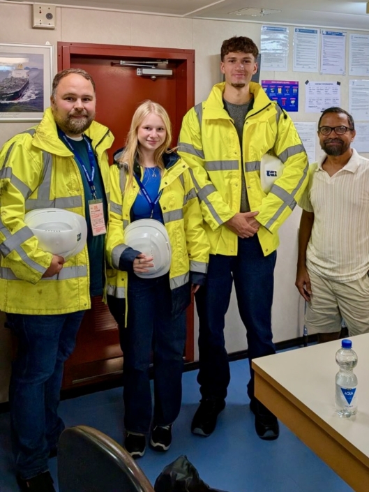 Das Foto zeigt einen der ersten Bordbesuche der neuen Freiwilligen Lea und Matteo aus Deutschland, die gemeinsam mit Diakon Thomas Kirschner (li.) im Amsterdamer Hafen an Bord eines Schiffes gegangen sind, um die Seeleute zu besuchen und ihnen ihre Hilfe anzubieten.