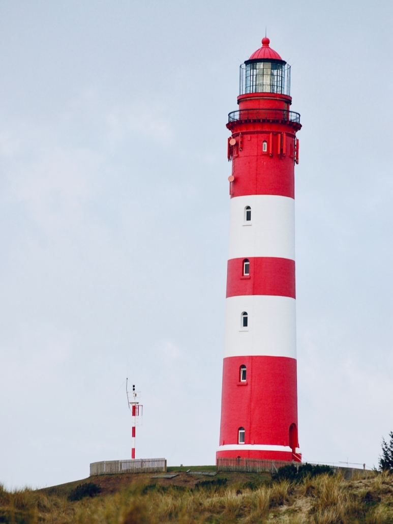 Das Foto zeigt den rot-weißgestrichenen Leuchtturm von Amrum.