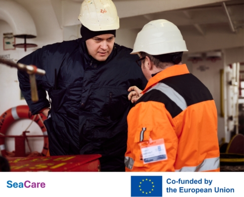 Das Bild setzt sich zusammen aus einem Foto von einem Seemann, der sich an Bord eines Schiffes mit einem Mitarbeiter der Deutschen Seemannsmission unterhält. Im unteren Drittel sind links der in hellblau und lila gehaltene Schriftzug des EU-Projektes Sea Care zu sehen. Rechts davon ist die blaue EU-Flagge mit zwölf goldenen Sternen zu sehen. Auf Englisch ist zu lesen, dass das Projekt von der EU mitfinanziert wurde.