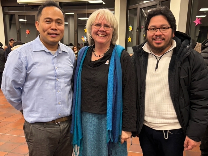 Das Foto zeigt Pater Ritchille Salinas SVD (links) im blauen, langärmeligen Hemd mit dunkelgrauer Stoffhose und braunen Lederschnürschuhen, daneben seine Kollegin Monica Döring (Stella Maris) und sein Ordensbruder und Nachfolger Pater Rey Bahian SVD.