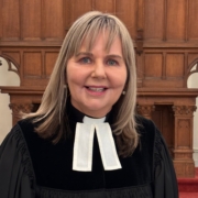 Das Foto zeigt Pastorin Karin Achtelstetter im schwarzen Talar im Altarraum einer Kirche in Antwerpen. Sie ist seit 1. März 2026 neue Seemannspastorin der Deutschen Seemannsmission Antwerpen und mit halber Stelle auch Pfarrerin der Deutschsprachigen Evangelischen Gemeinde in Antwerpen und Mol. Karin Achtelstetter hat glatte, halb lange Haare in einem dunklen Blondton.